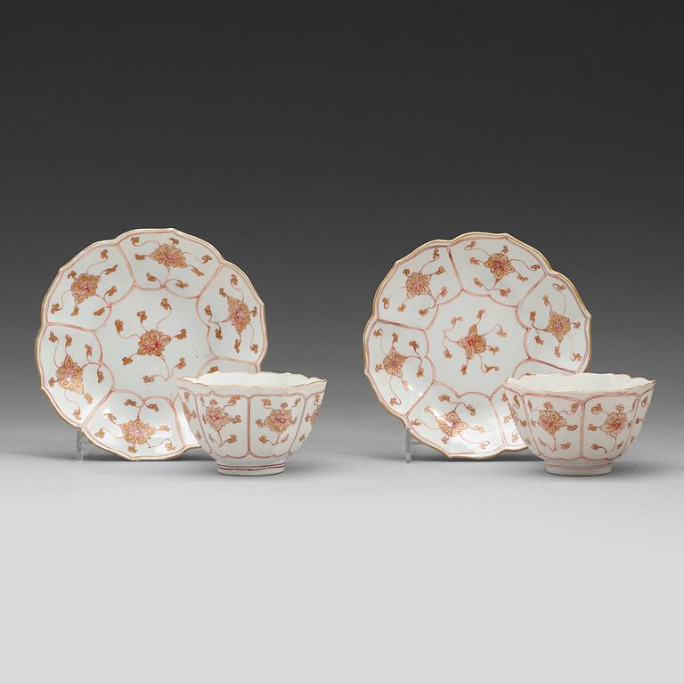 A pair of 'rouge de fer and gold' cups with stands, Qing dynasty, Qianlong (1736-95).