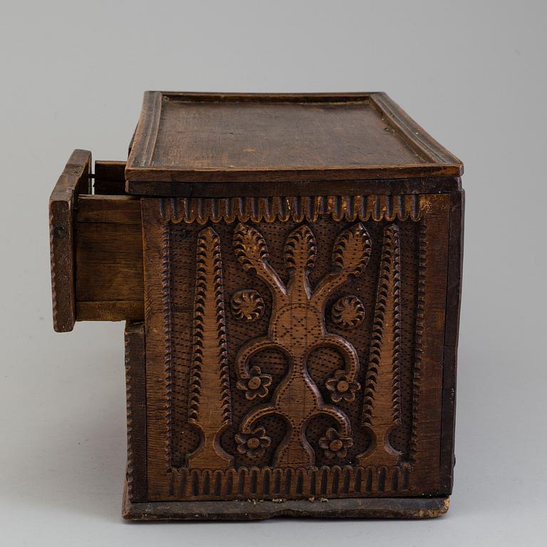 A 19th century wooden box with drawers.