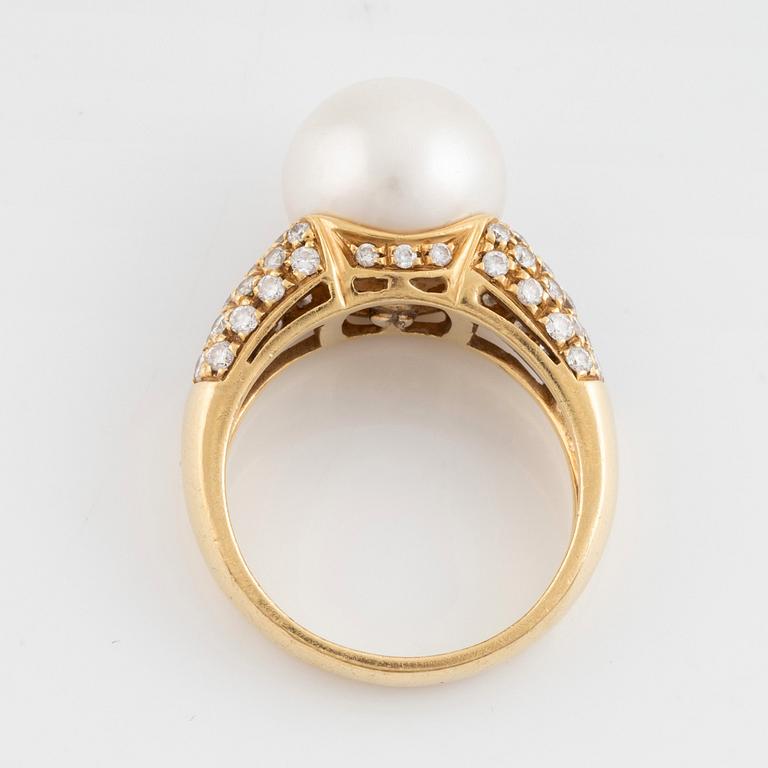 An 18K gold ring set with a cultured South Sea pearl and round brilliant-cut diamonds.