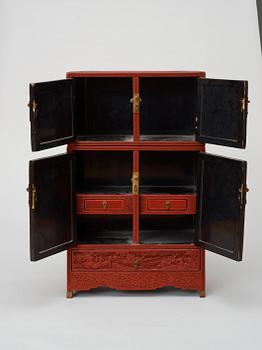 A well carved Cinnaber lacquer 'Kang'Cabinet, Qing dynasty, 18/19th Century.