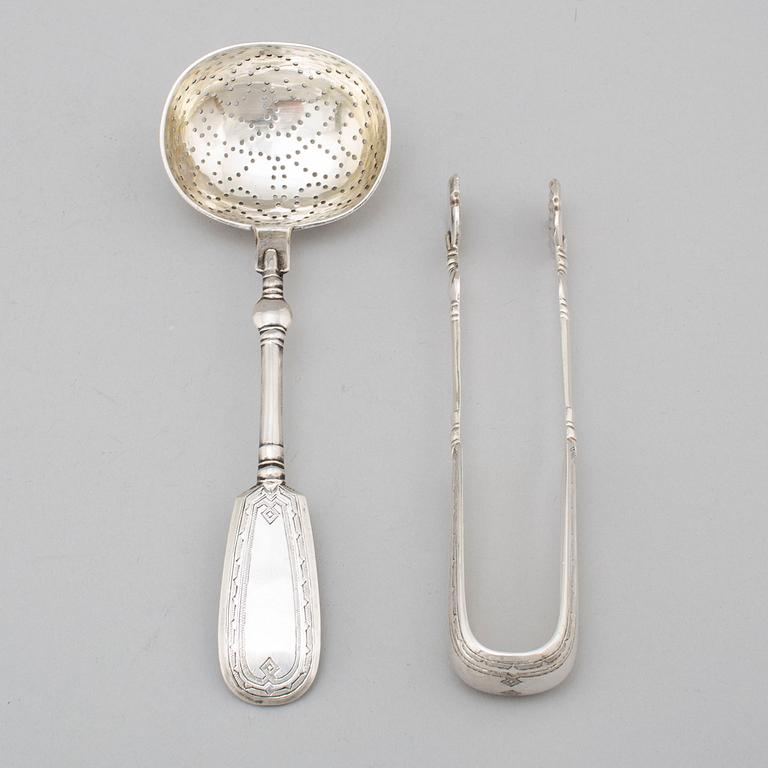 A Russian 19th century silver straining spoon and a pair of sugar tongs, St. Petersburg 1893.