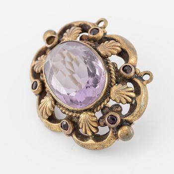 Brooch, gilded metal with a faceted amethyst.
