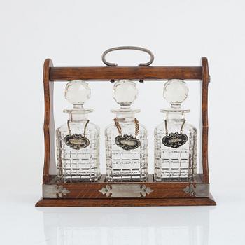 A mahogany and electroplate tantalus witht three carafes, circa 1900.