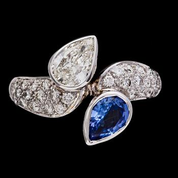 179. RING, GUBELIN, droppslipad diamant, ca 0.60 ct och blå safir, samt mindre briljantslipade diamanter.