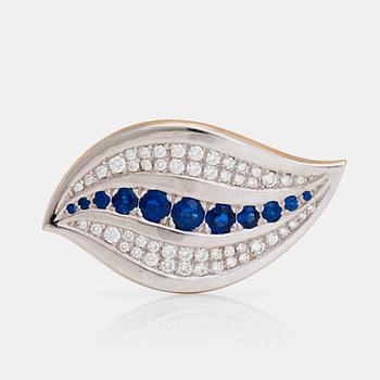 1207. A brooch set with round, mixed-cut sapphires and round, brilliant-cut diamonds.