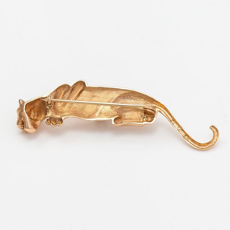 A panther brooch made of 14K gold and with emeralds.
