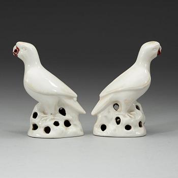 A pair of white and red glazed figures of parrots, late Qing dynasty.