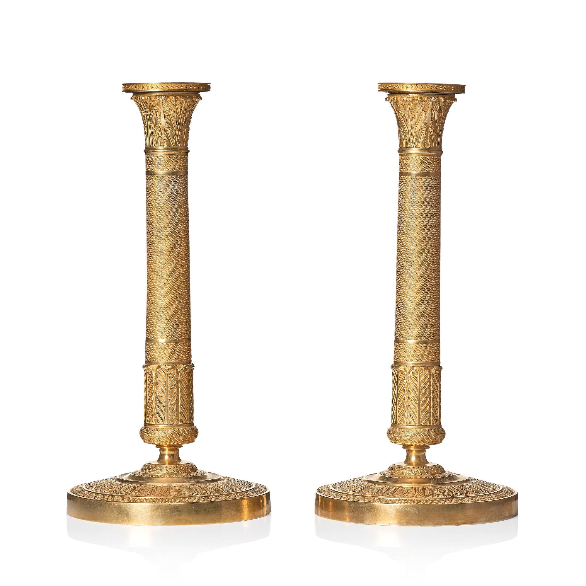 A pair of French Empire ormolu candlesticks, early 19th century.