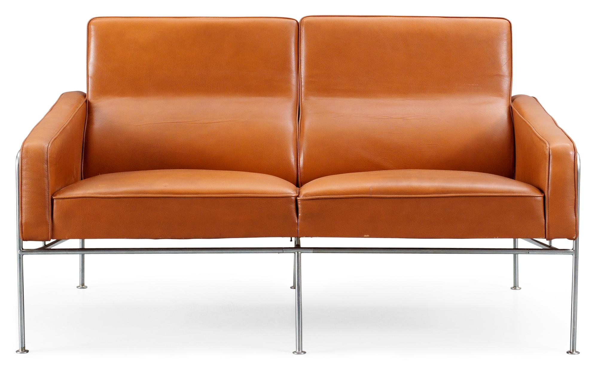 An Arne Jacobsen two-seated brown leather and chromed steel sofa by Fritz Hansen, Danmark.