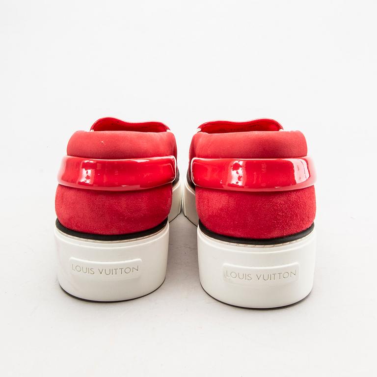 A pair of Louis Vuitton sneakers.