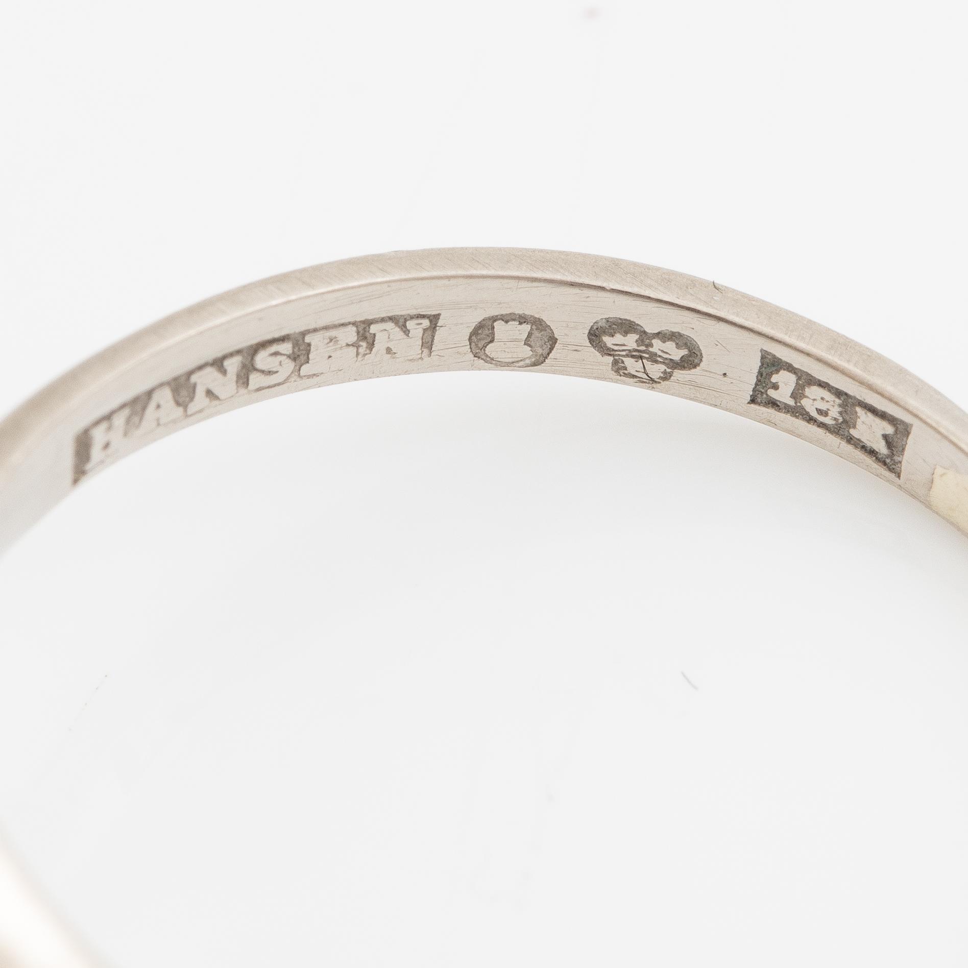 Ring, 18K vitguld med en briljantslipad diamant och  tre mindre briljantslipade diamanter.