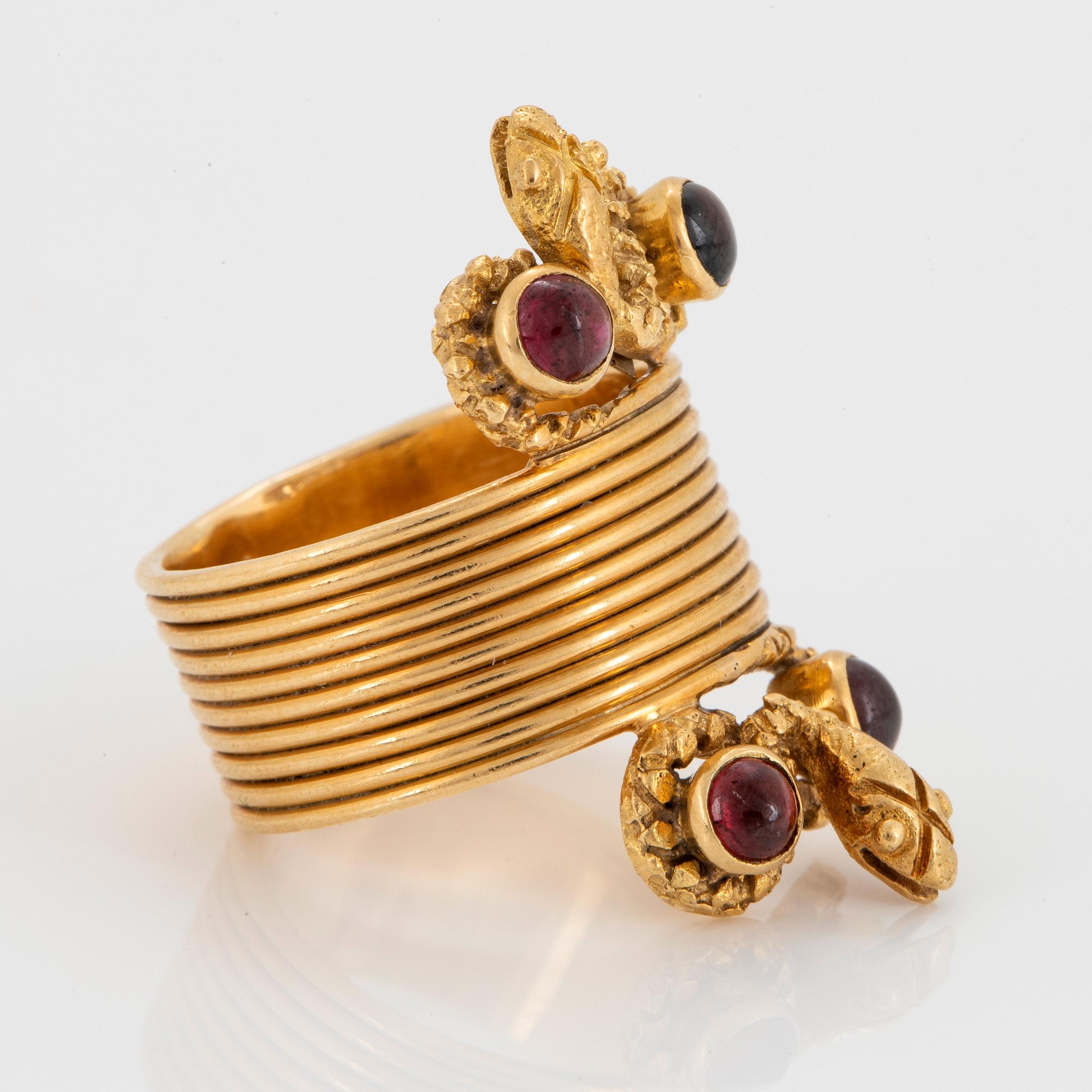 An 18K gold ring set with cabochon-cut garnets design Ilias Lalaounis.