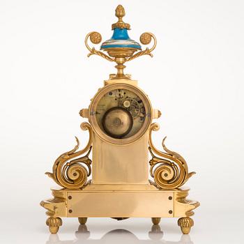 A mid-19th-century French gilt-brass mantel clock with a pair of candelabra by Dussault.