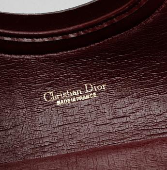 A red monogram canvas handbag by Christian Dior.
