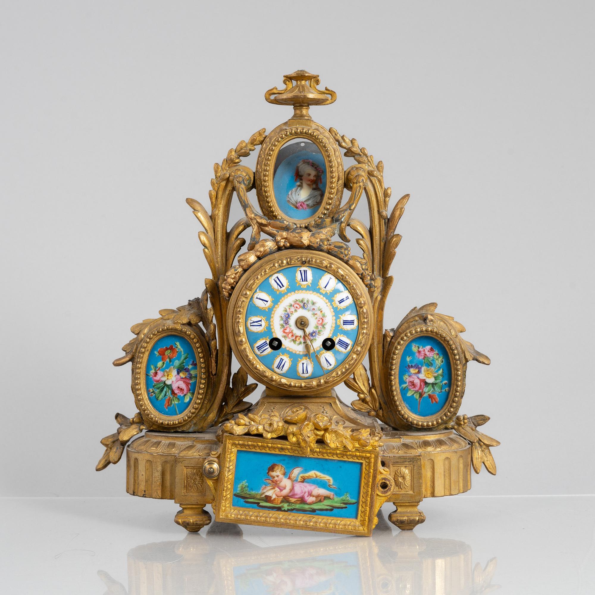 A Louis XVI style mantel clock and a pair of candelabra, circa 1900.