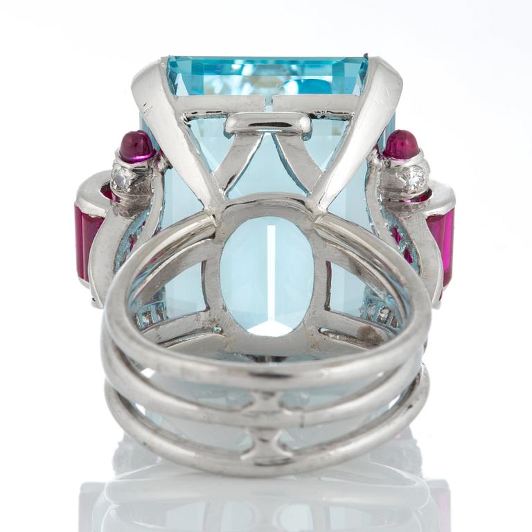 A ring set with a step-cut aquamarine with a weight of ca 35 cts and step-cut rubies ca 1.50 cts.