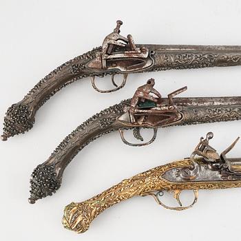 A pair of miquelet pistols and an flintlock pistol, 18/19th Century.