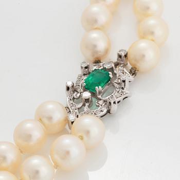 A two strand cultured pearl necklace clasp in 18K white gold set with a faceted emerald.