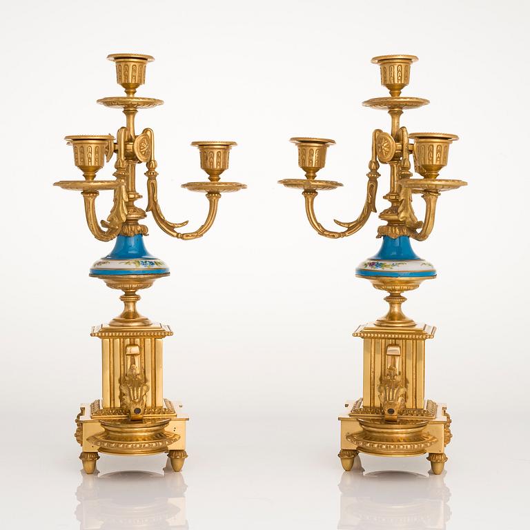 A mid-19th-century French gilt-brass mantel clock with a pair of candelabra by Dussault.