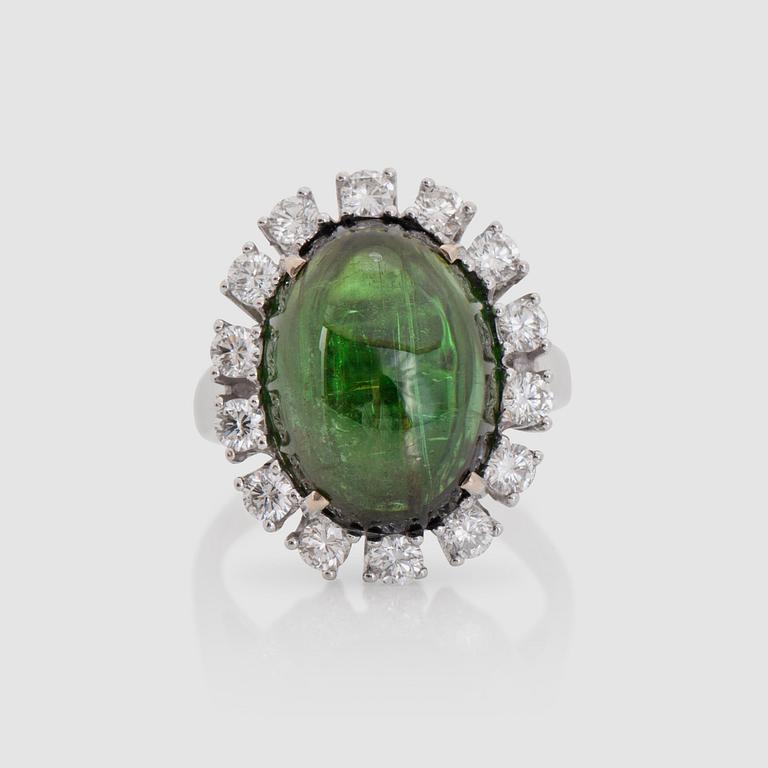 A cabochon-cut 10.94 ct green tourmaline and brilliant-cut diamond ring. Total carat weight of diamonds 1.02 cts.