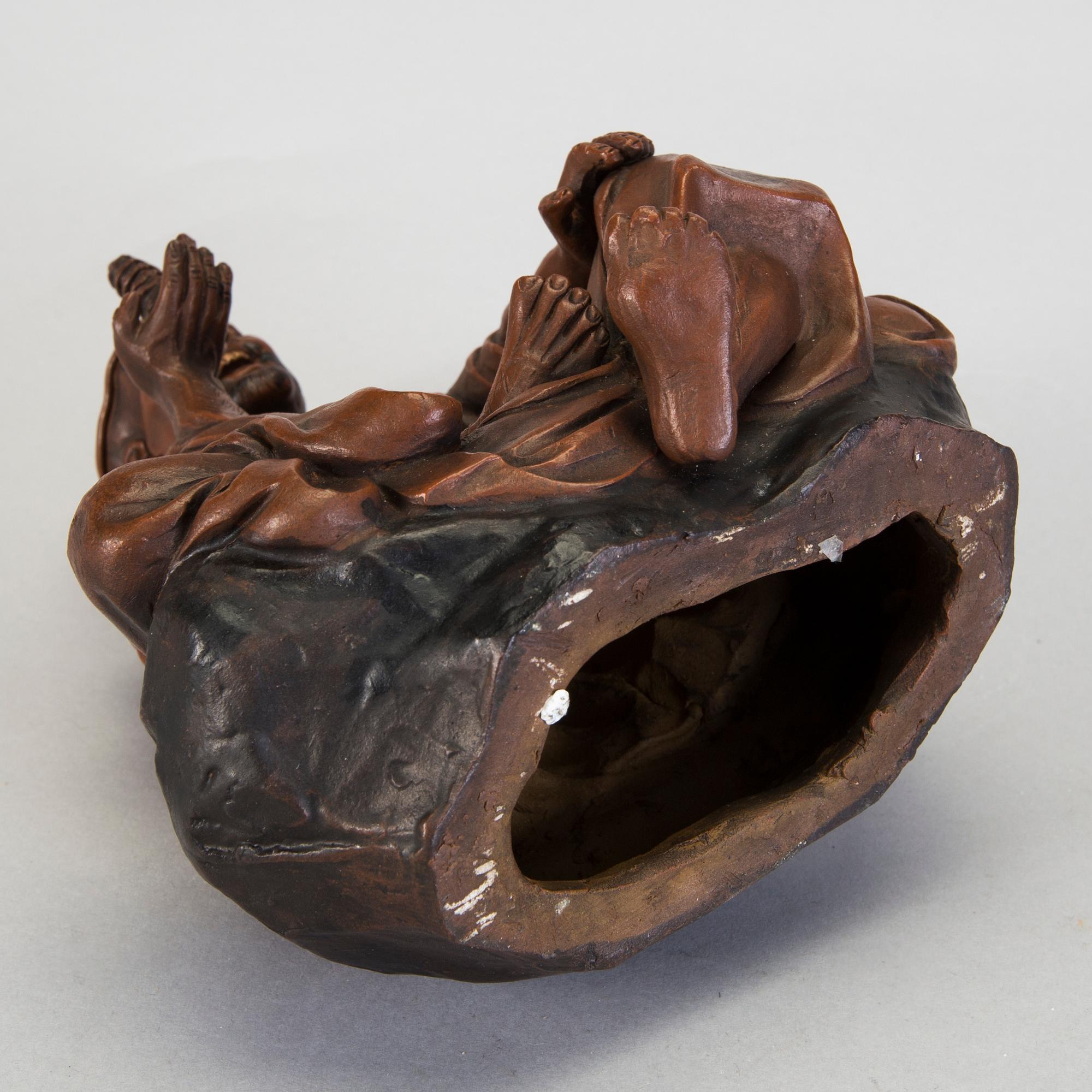 A Japanese earthenware seated figure of a man holding a pagoda, 20th century.