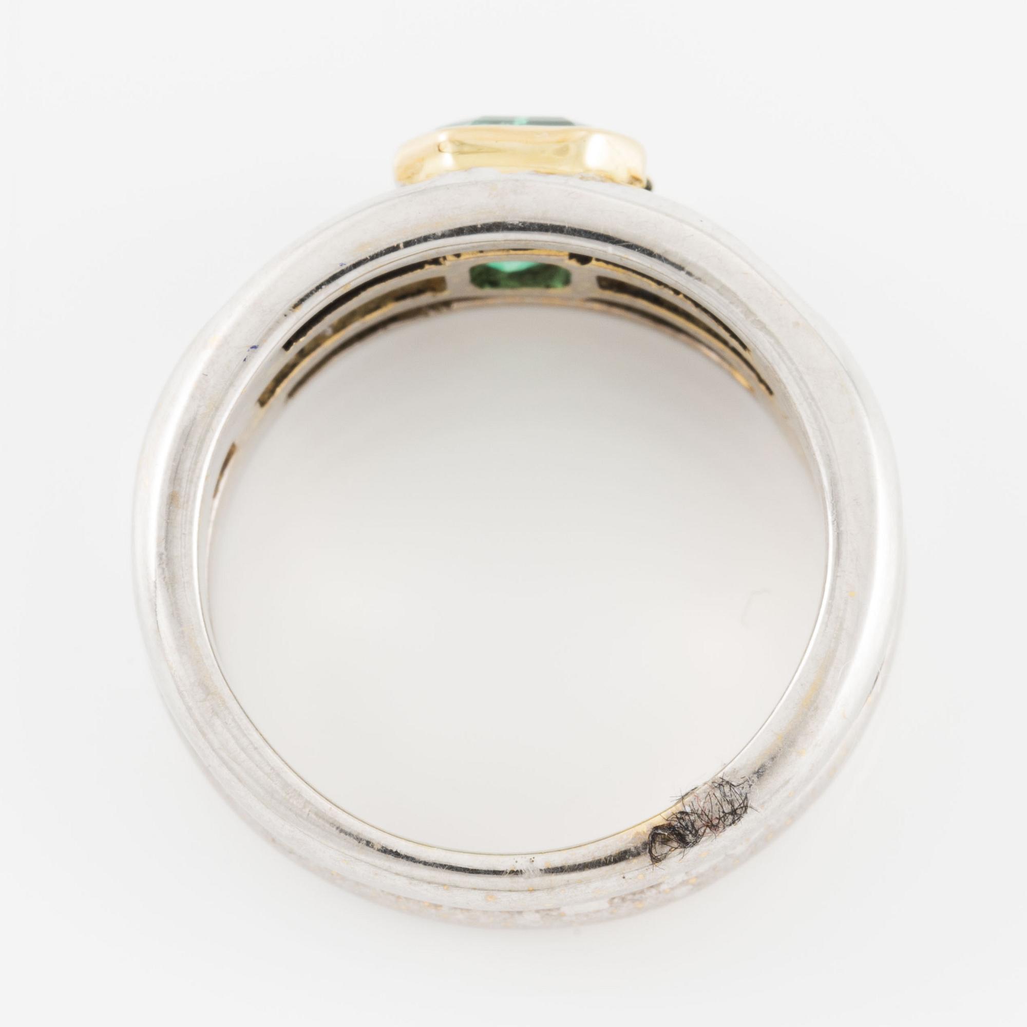 A ring in 18K gold set with a faceted emerald and baguette-cut diamonds.
