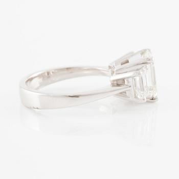 An 18K white gold ring set with three emerald-cut diamonds.