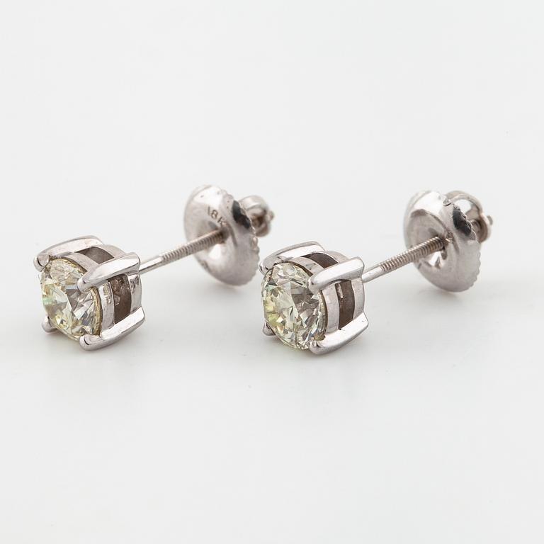 A pair of brilliant cut diamond earrings.