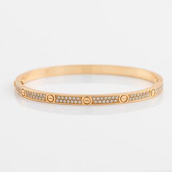 A Cartier "Love" bracelet small model in 18K gold set with round brilliant-cut diamonds. size 16, total weight 17 g. Signed Cartier, numbered DOT70...