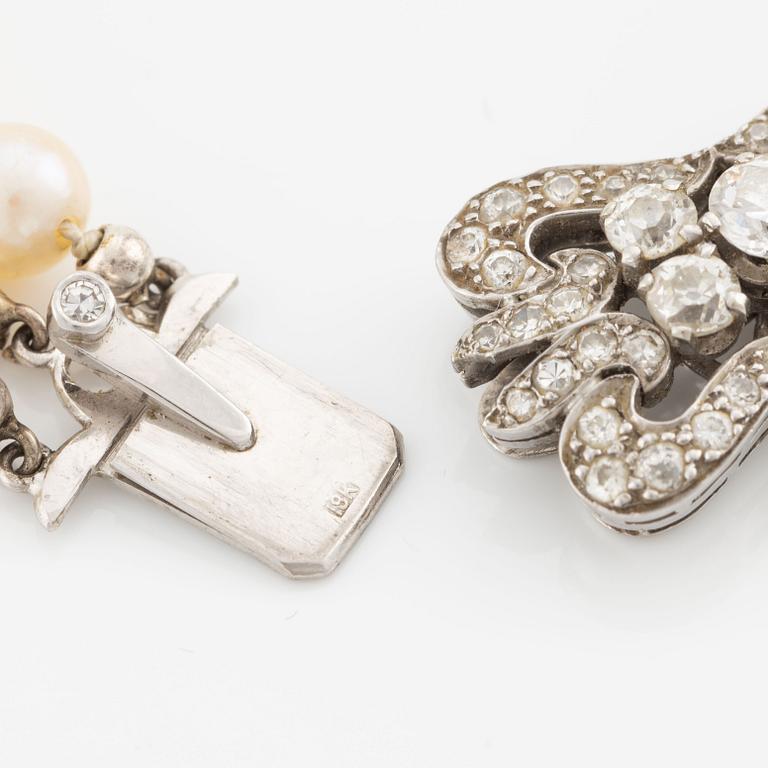 A three-strand cultured pearl necklace with an 18K white gold clasp with round brilliant-cut diamonds.