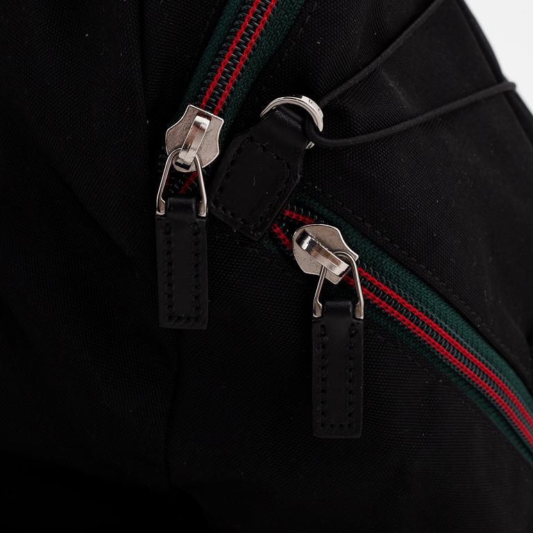 Gucci, a black canvas backpack.