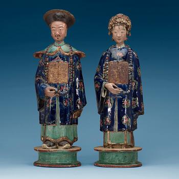 A pair of pottery figures of a Chinese official and his lady, Qing dynasty.