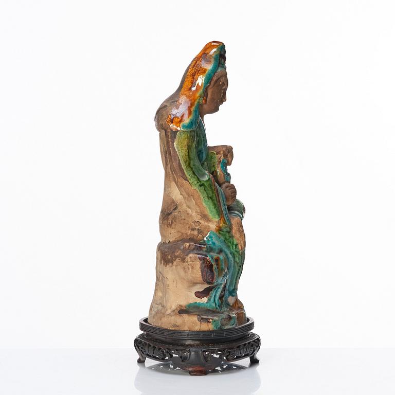 A green, turquoise, yellow and aubergine glazed figure of Guanyin, late Ming dynasty (1368-1644).