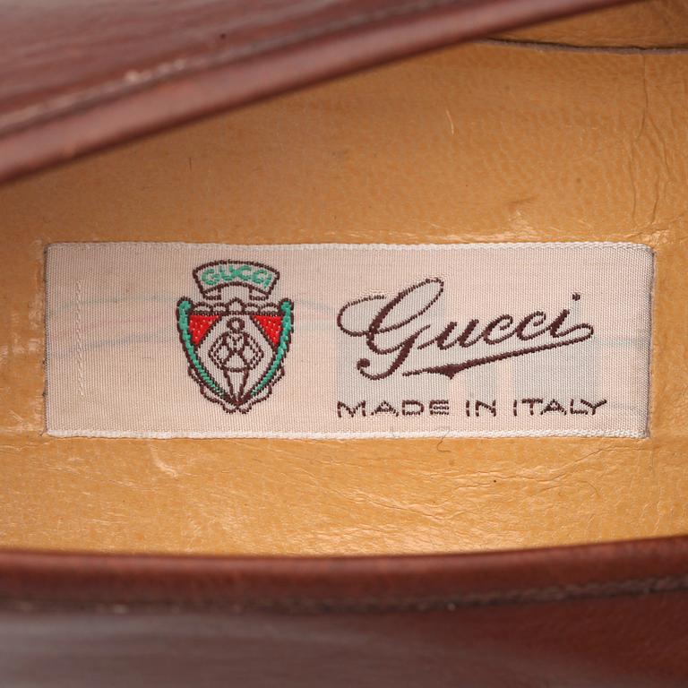 GUCCI, a pair of brown leather loafers.