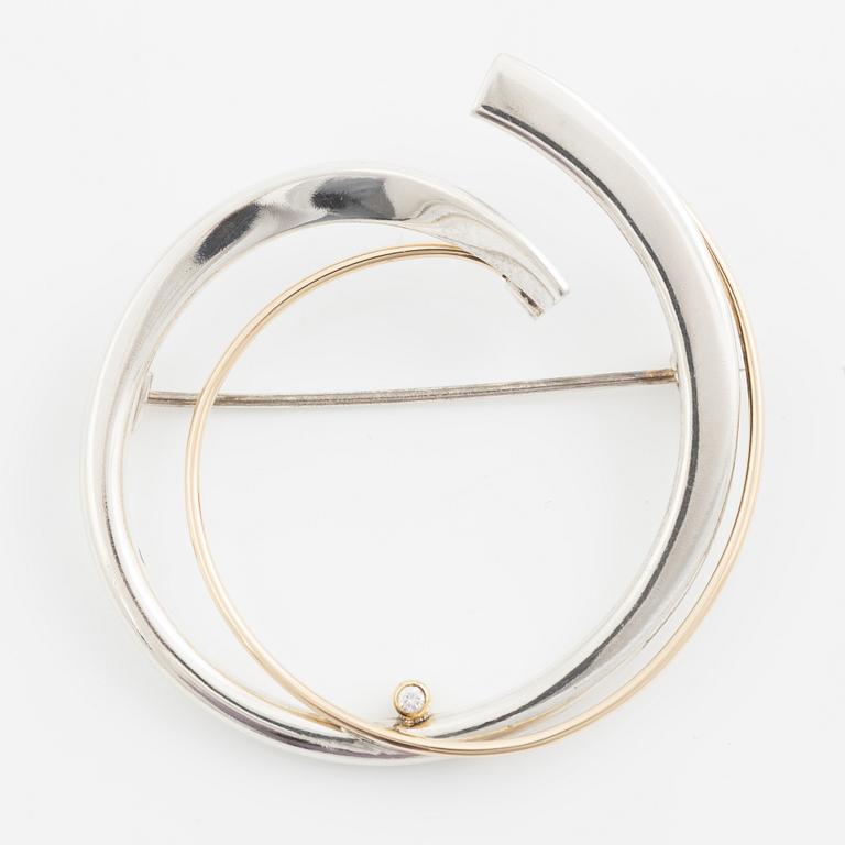 Brosch silver med en rund briljantslipad diamant.