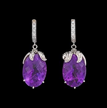 1058. A pair of amethyst and brilliant cut diamond earrings, tot. app. 0.40 cts.