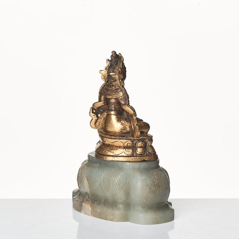 A gilt bronze figure of Amittayus seated on a later base of nephrite, Tibeto-Chinese, late 19th Century.