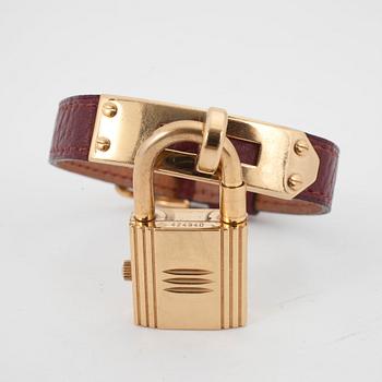 HERMÈS, a burgundy red leather braclet with 14k gold plated watch, "Kelly Lock".