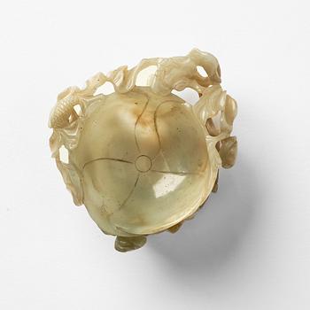 A carved Chinese nephrite cup in the shape of a lotus leaf, late Ming dynasty.