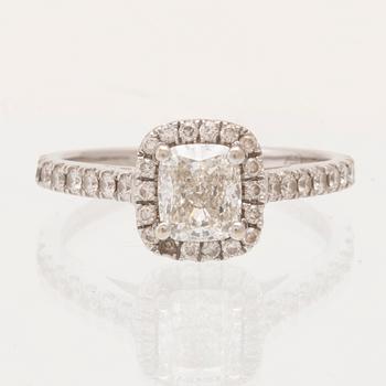 An 18K white gold ring set with a modified cushion-cut diamond and round brilliant-cut diamonds.