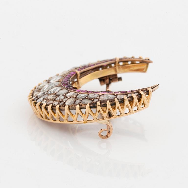 Brosch guld med rosenslipade diamanter och fasettslipade rubiner i form av en halvmåne.