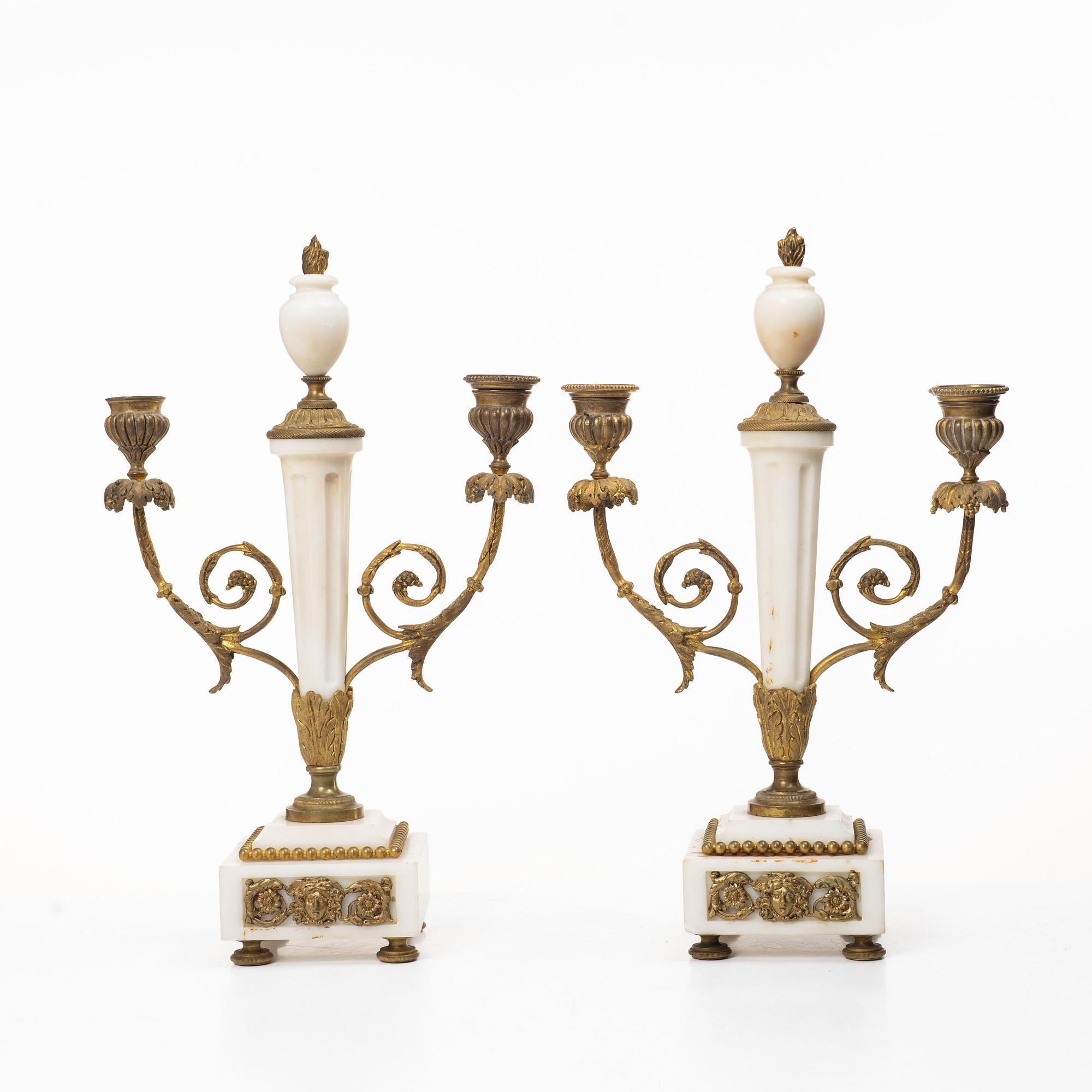 A Louis XVI-style mantle clock and a pair of candelabras. Early 20th century.