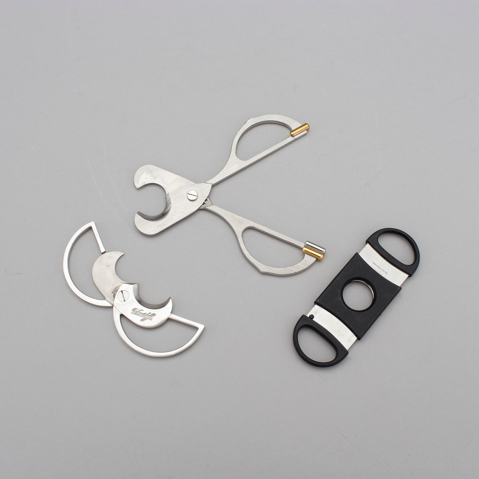 Two cigar cutters from Davidoff and must de Cartier in original cases.