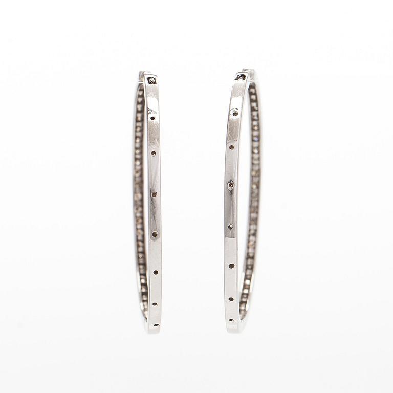 A pair of 14K white gold  hoop earrings with diamonds.