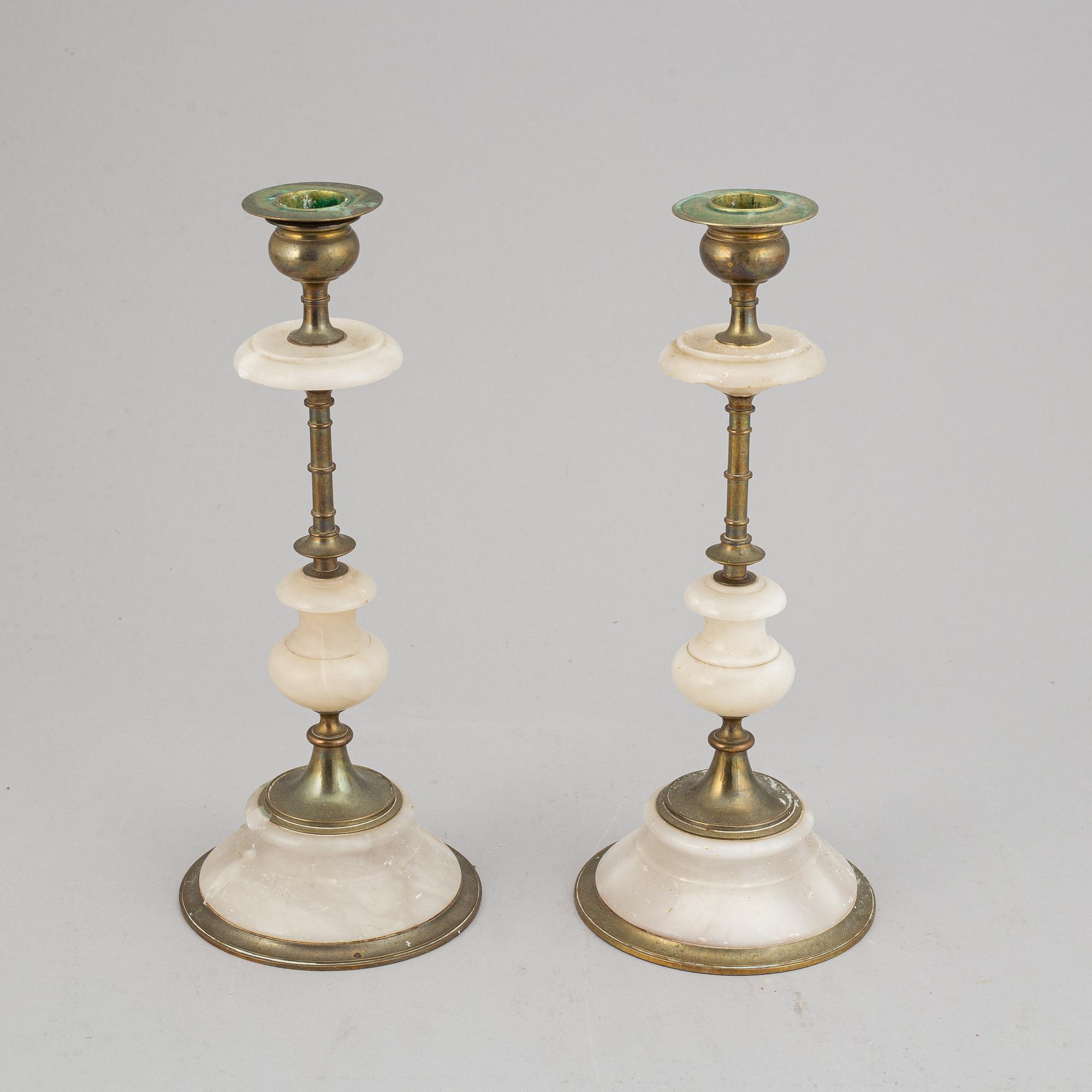 An alabaster mantle clock and pair of candlesticks, circa 1900.