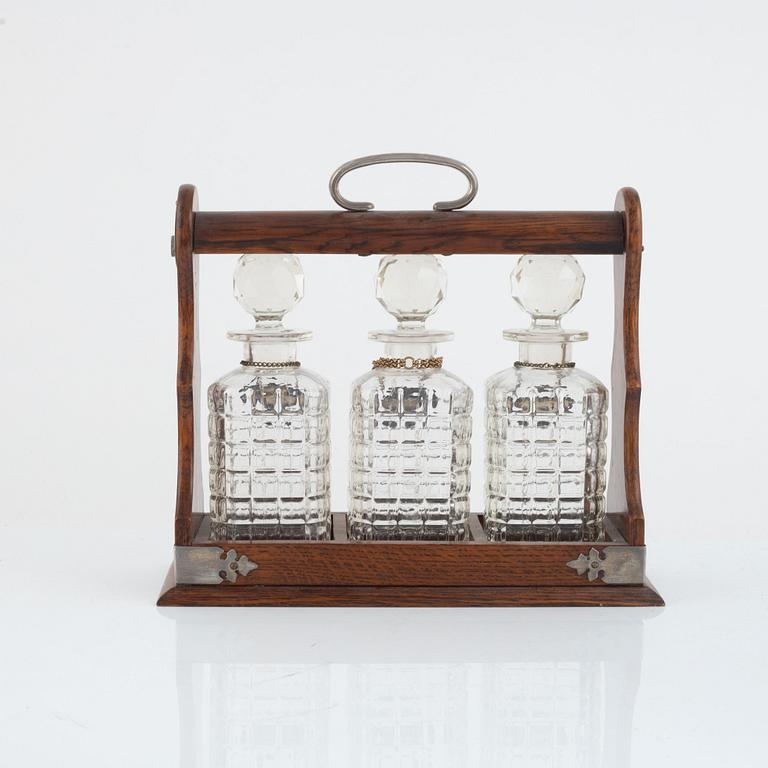 A mahogany and electroplate tantalus witht three carafes, circa 1900.