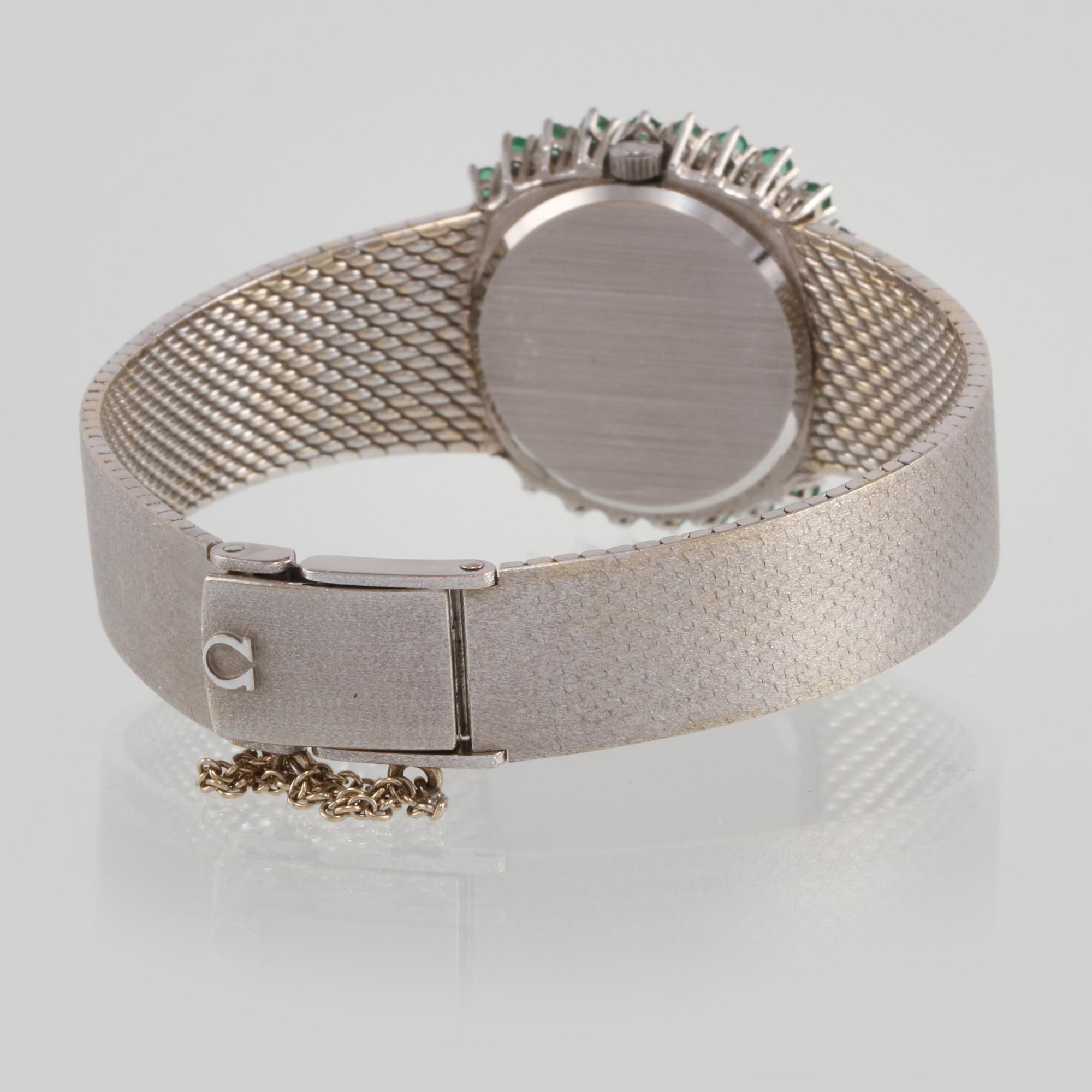 ARMBANDSUR, Omega, 18K vitguld med briljantslipade diamanter samt fasettslipade smaragder. Vikt 64,6 gram.