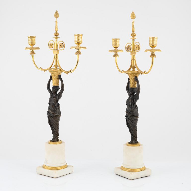 A pair of French Louis XVI ormolu, marble, and patinated bronze two-branch candelabra, late 18th century.