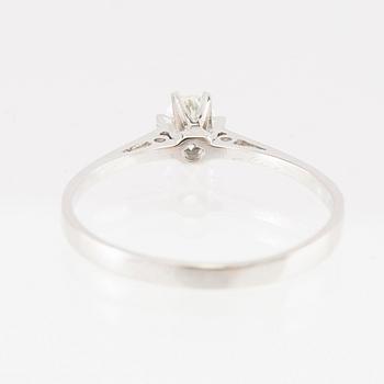 An 18K white gold solitaire ring set with a round brilliant-cut diamond.