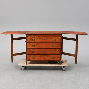 A 19th Century chest of drawers with a table top.